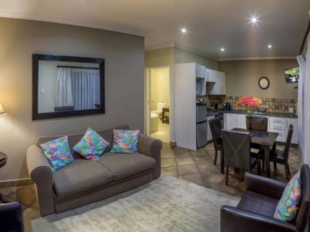 Open-plan lounge with sofa, dining table and fitted kitchen.
