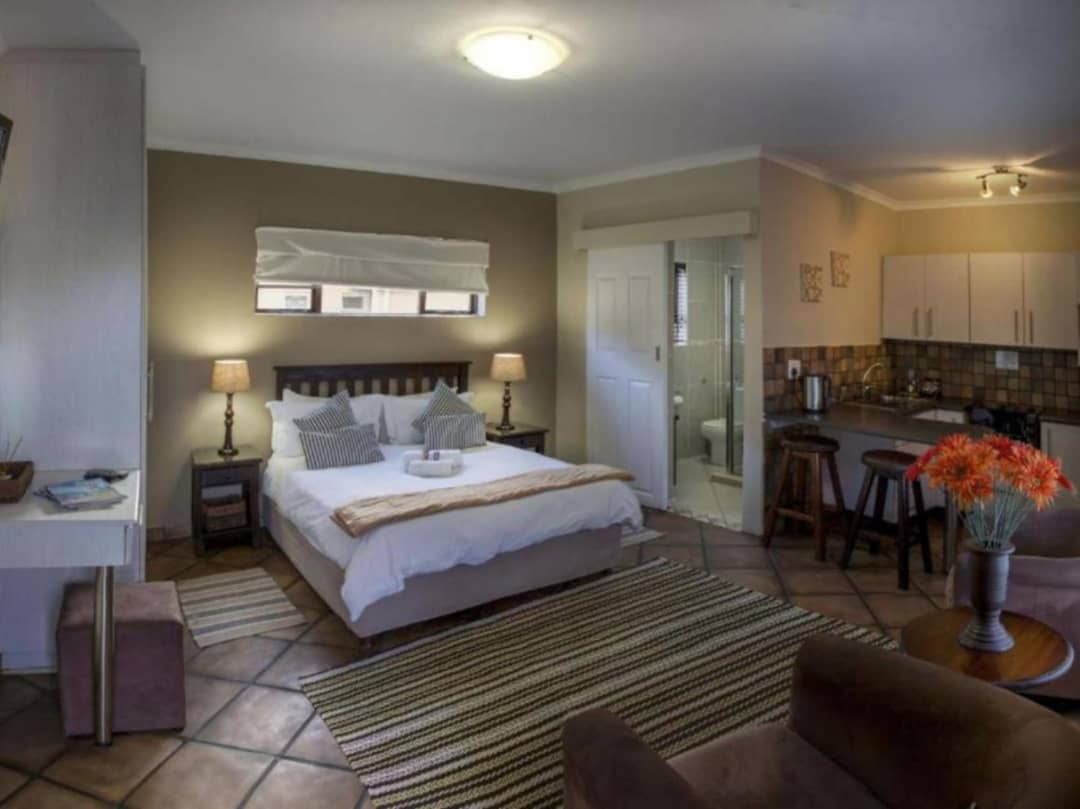 Studio room with double bed, kitchenette, and seating area.